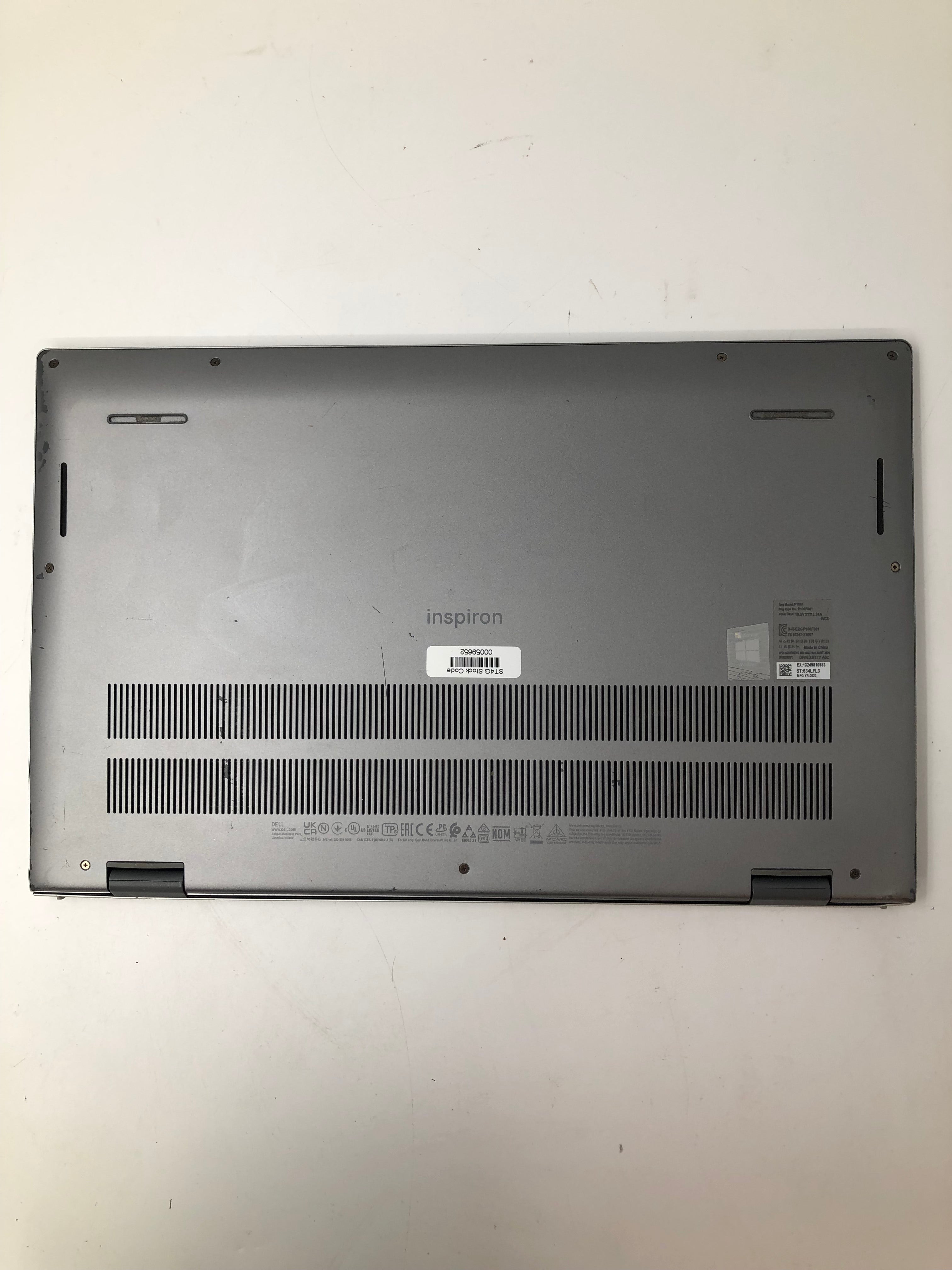 Dell Inspiron 15 5510 bottom view showing serial tags and vents