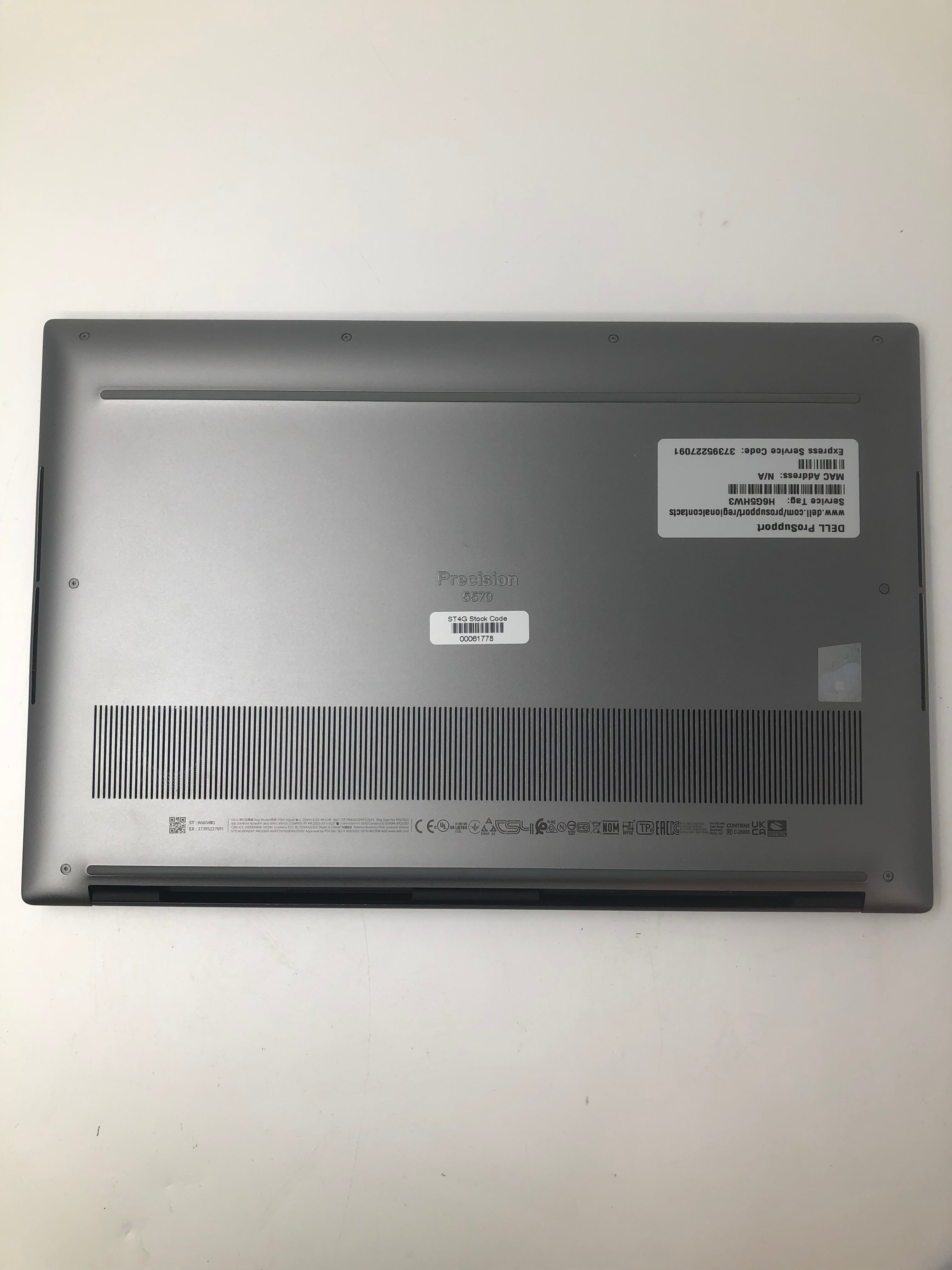 Dell Precision 5570 bottom view showing serial tags and vents
