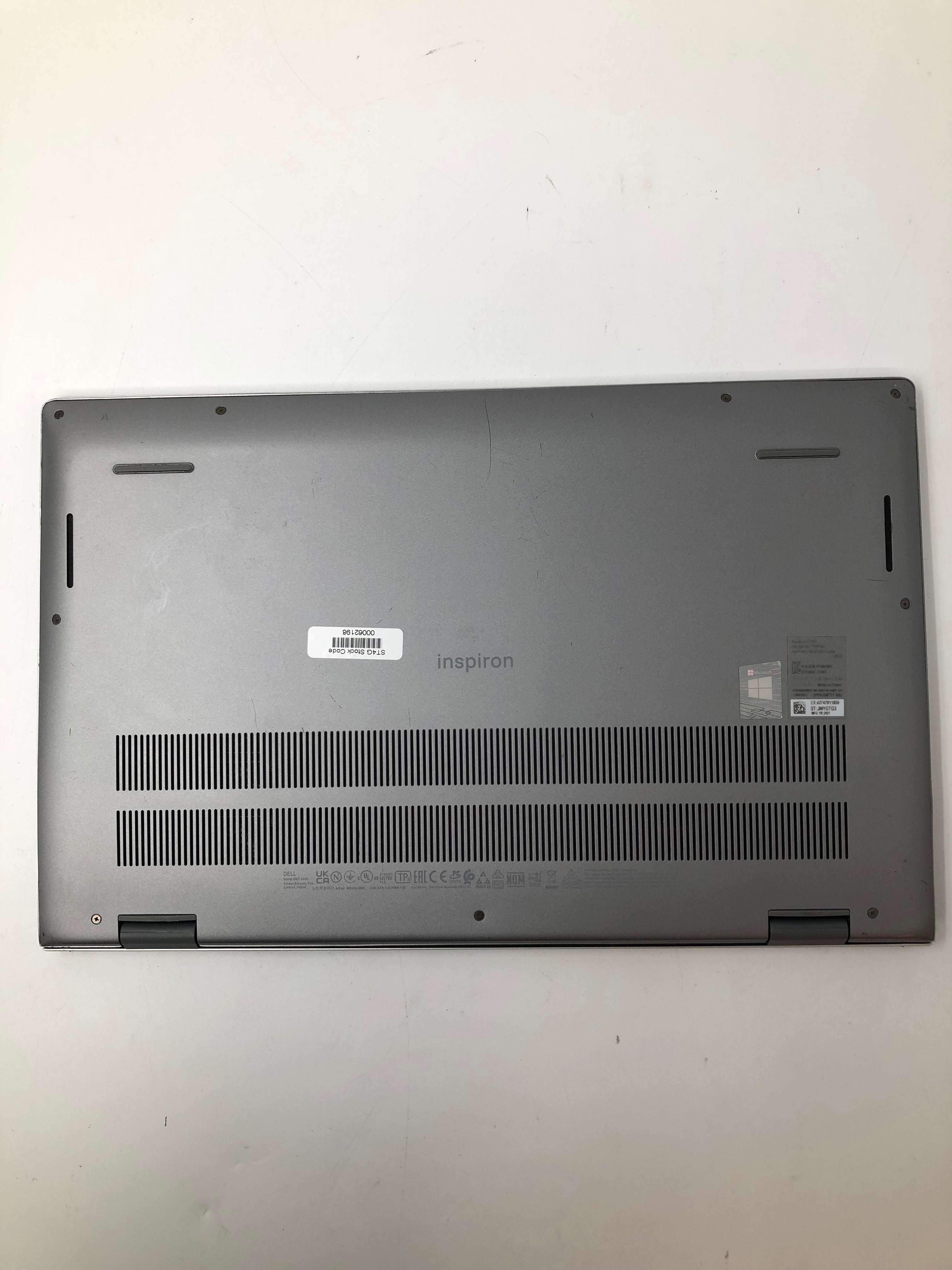 Dell Inspiron 15 5510 bottom view showing serial tags and vents